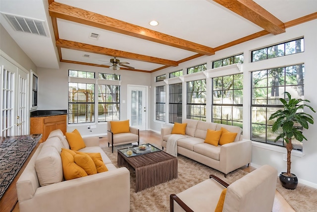 sunroom / solarium featuring ceiling fan, beamed ceiling, and a healthy amount of sunlight