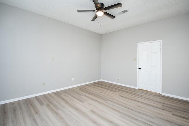 spare room featuring ceiling fan, light hardwood / wood-style flooring, and a textured ceiling