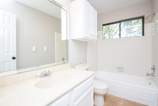 full bathroom featuring tile patterned flooring, vanity, a textured ceiling, toilet, and tiled shower / bath