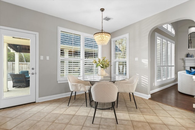 dining area with light tile patterned flooring and a notable chandelier