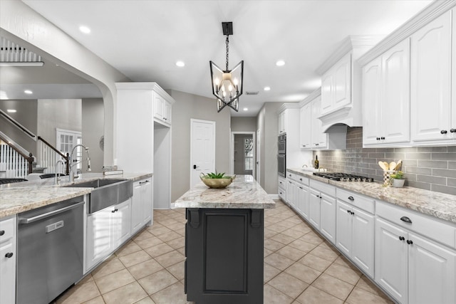 kitchen featuring pendant lighting, appliances with stainless steel finishes, sink, and white cabinets