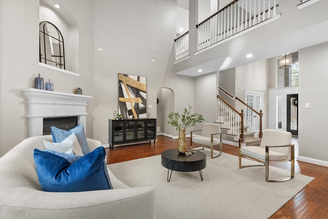 living room with hardwood / wood-style flooring and a towering ceiling