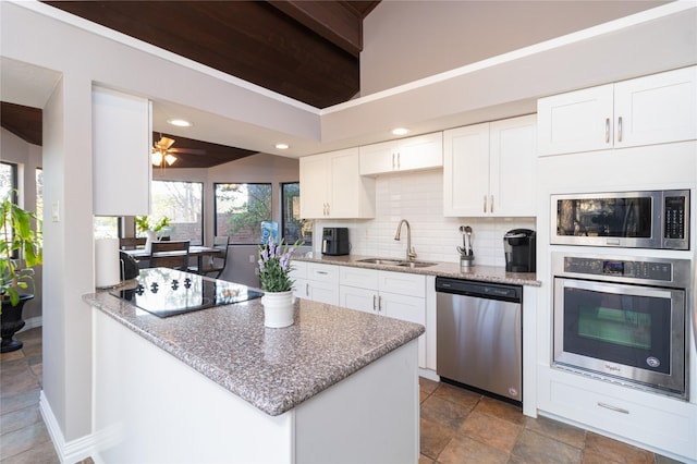 kitchen featuring sink, white cabinetry, stainless steel appliances, tasteful backsplash, and light stone countertops