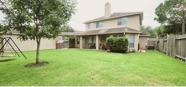 back of house featuring a yard