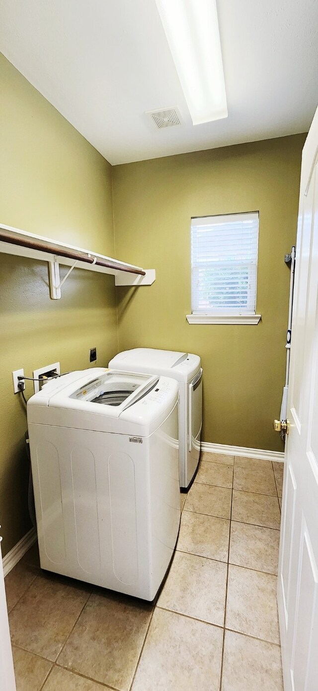 washroom featuring light tile patterned floors and washing machine and dryer