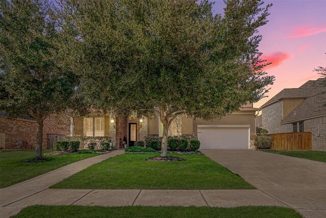 view of front of property with a garage and a lawn