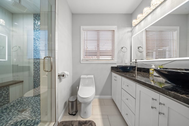 bathroom featuring a shower with door, vanity, tile patterned flooring, and toilet