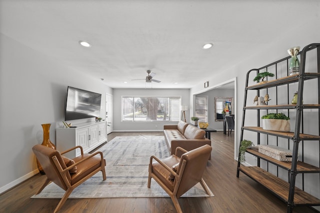 living room with ceiling fan and dark hardwood / wood-style flooring