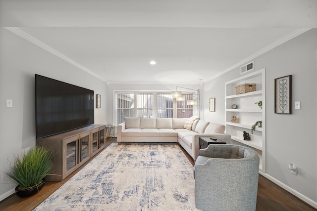 living room featuring built in shelves, ornamental molding, and dark hardwood / wood-style flooring