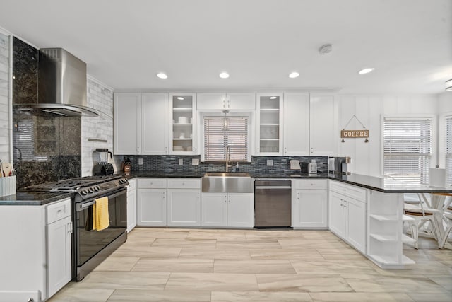 kitchen featuring white cabinetry, wall chimney exhaust hood, sink, and gas stove