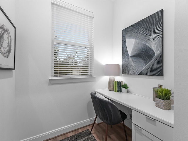 home office featuring hardwood / wood-style flooring and built in desk