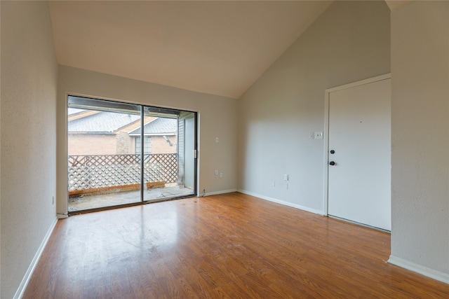 unfurnished room with hardwood / wood-style floors and high vaulted ceiling