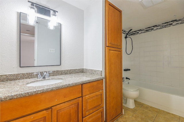 full bathroom with tile patterned flooring, tiled shower / bath, vanity, and toilet