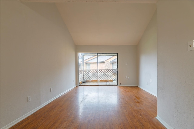 spare room featuring lofted ceiling and light hardwood / wood-style flooring