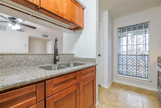 kitchen featuring light tile patterned flooring, sink, and ceiling fan