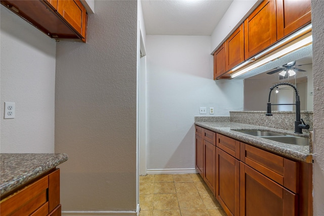 kitchen with sink, light tile patterned floors, and ceiling fan