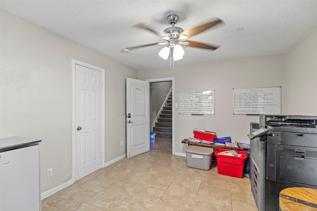 miscellaneous room featuring ceiling fan and a textured ceiling