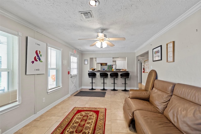 tiled living room with crown molding, plenty of natural light, and a textured ceiling