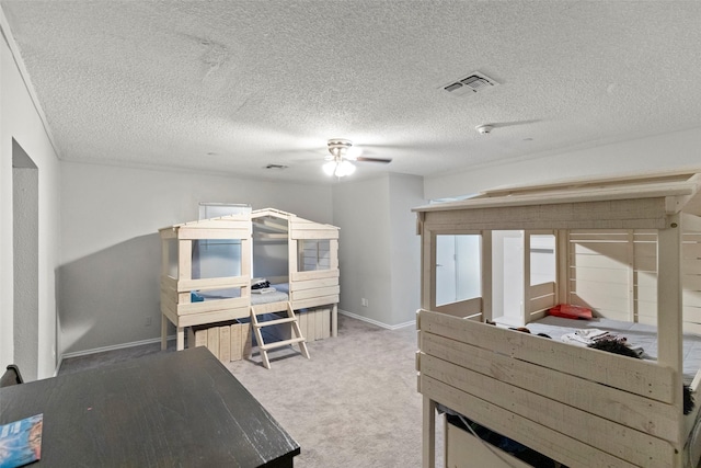 bedroom with a textured ceiling, carpet floors, and ceiling fan