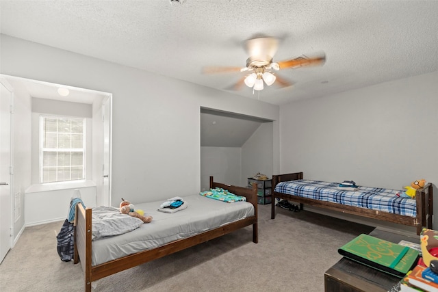 bedroom featuring light carpet, ceiling fan, and a textured ceiling