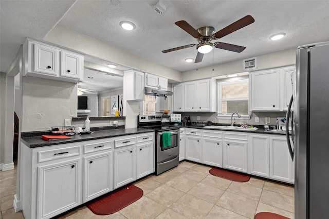 kitchen featuring stainless steel appliances, sink, white cabinets, and a textured ceiling