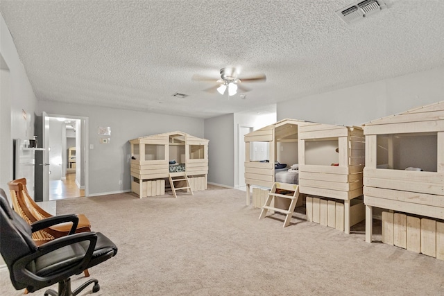 carpeted bedroom featuring ceiling fan and a textured ceiling