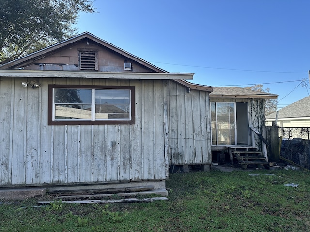 view of side of home with a yard