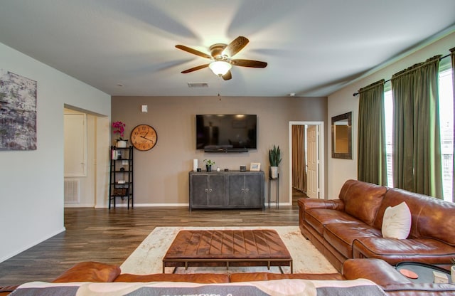 living room featuring dark wood-type flooring and ceiling fan