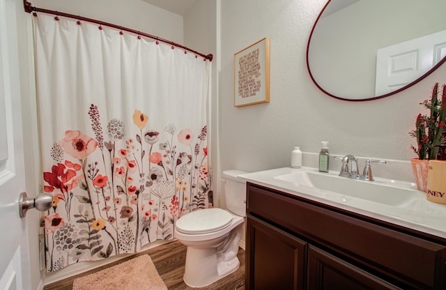 bathroom with hardwood / wood-style flooring, vanity, curtained shower, and toilet