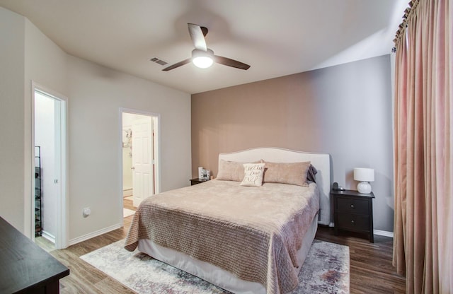 bedroom with connected bathroom, hardwood / wood-style floors, and ceiling fan