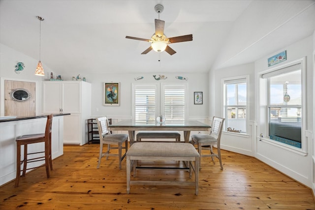 dining space with vaulted ceiling, ceiling fan, and light wood-type flooring