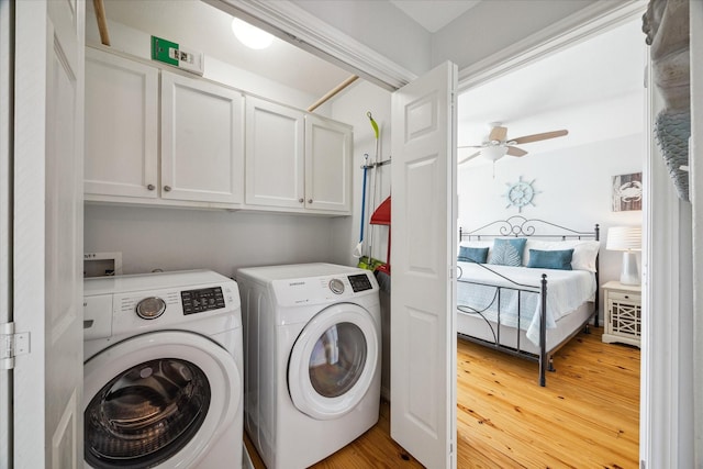 laundry room with hardwood / wood-style flooring, cabinets, ceiling fan, and washer and dryer