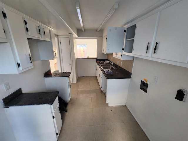 kitchen with white cabinetry, sink, and light tile patterned floors