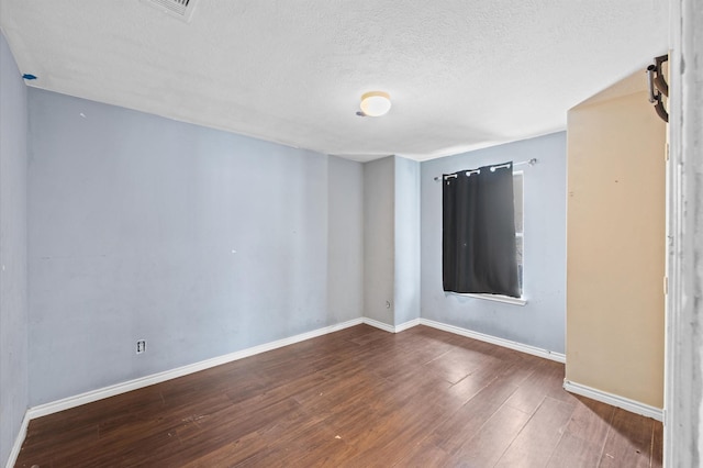 unfurnished room with dark hardwood / wood-style flooring and a textured ceiling