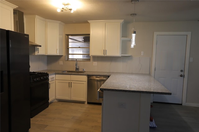 kitchen with stone countertops, black appliances, white cabinetry, sink, and kitchen peninsula