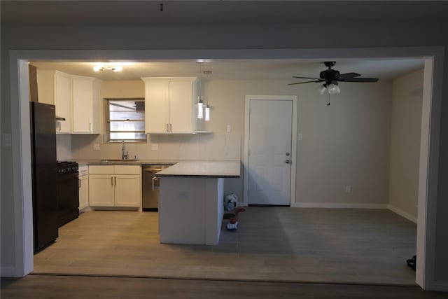 kitchen featuring sink, white cabinetry, hanging light fixtures, hardwood / wood-style floors, and black appliances