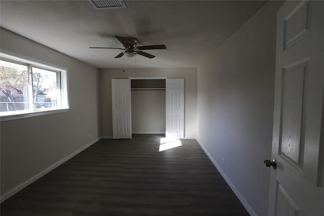 unfurnished bedroom featuring ceiling fan, dark hardwood / wood-style floors, a closet, and a textured ceiling