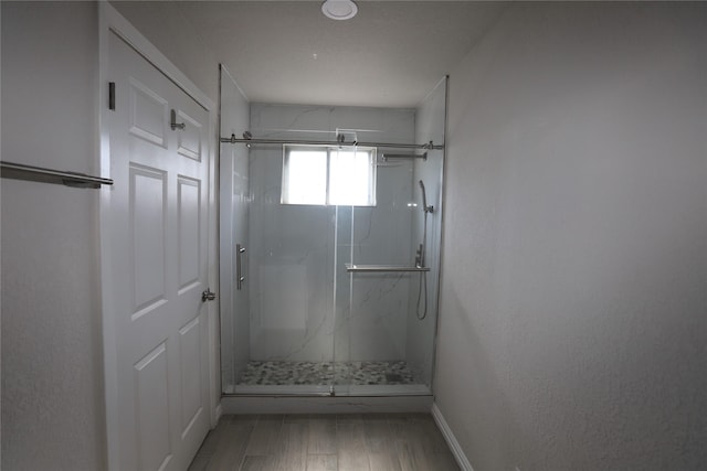 bathroom with hardwood / wood-style floors and a shower with shower door