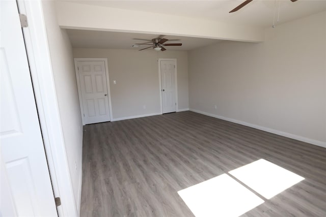 empty room with ceiling fan, hardwood / wood-style flooring, and beamed ceiling