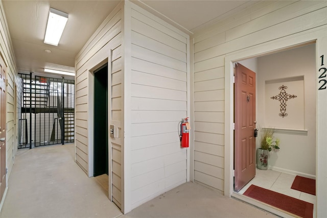 hall featuring wooden walls