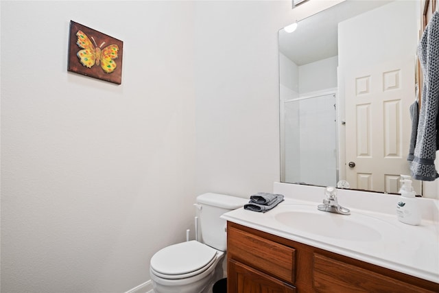 bathroom featuring vanity, a shower with shower door, and toilet