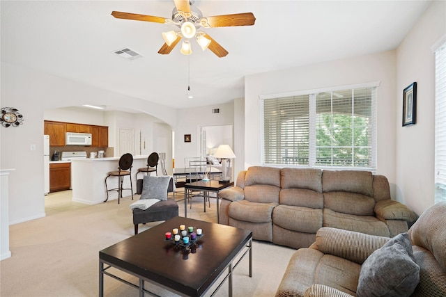 living room featuring light carpet and ceiling fan