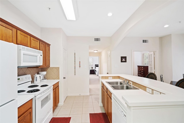 kitchen with light tile patterned floors, sink, white appliances, an island with sink, and decorative backsplash