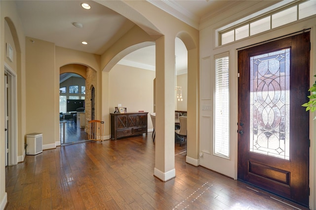 entryway featuring ornamental molding and dark hardwood / wood-style floors