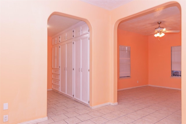 tiled spare room with ceiling fan