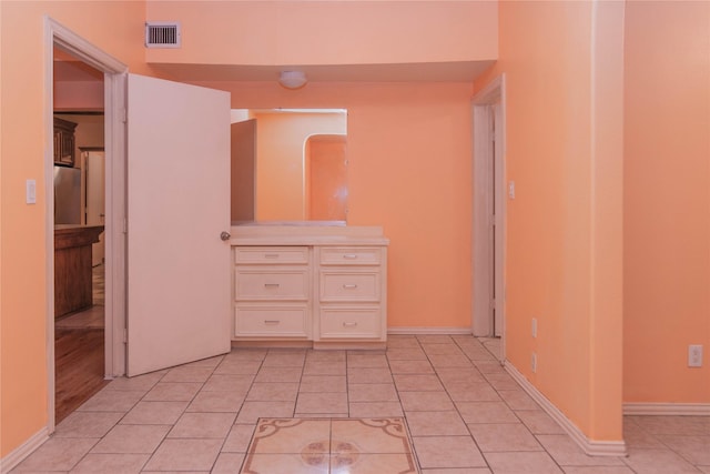 interior space with fridge and light tile patterned floors