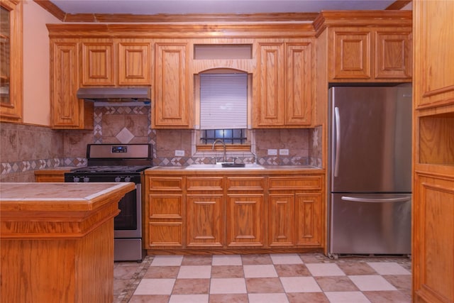 kitchen featuring stainless steel appliances, sink, tile counters, and backsplash