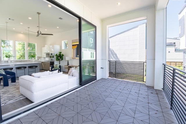 interior space with an outdoor living space, sink, and ceiling fan