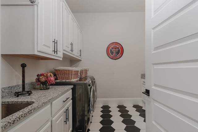 clothes washing area featuring cabinets and washing machine and dryer