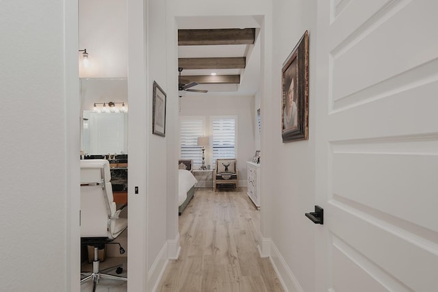 hallway with beam ceiling and light hardwood / wood-style floors